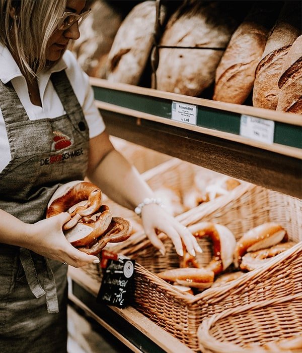Verkäuferin der Brotschmiede mit frischen Brezeln
